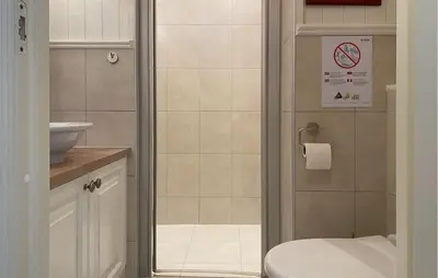 a bathroom with a shower with a toilet and a sink at Amazing Home In Eiksund With Kitchen in Eiksund