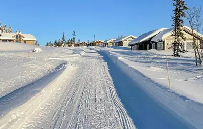 a road covered in snow with houses in the background at Stunning Home In Eggedal With Wifi in Eggedal