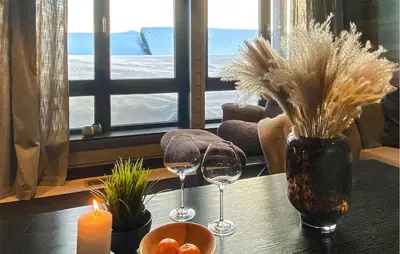 a table with two wine glasses and a candle at Amazing Apartment In Noresund With Wifi in Noresund