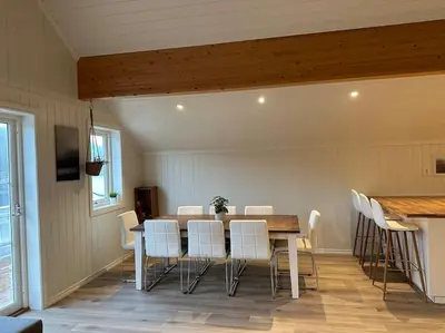 a dining room with a table and white chairs at Rorbu i Gilsvågen - Egen Brygge - Båtutleie in Blænes