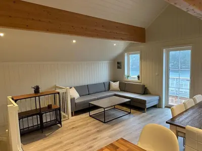 a living room with a couch and a table at Rorbu i Gilsvågen - Egen Brygge - Båtutleie in Blænes