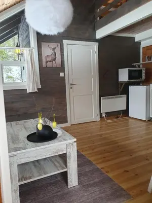 a living room with a table and a white door at Kvamskogen & Hardanger Holliday homes in Norheimsund