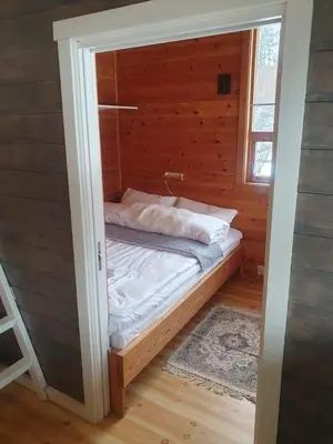 a small bedroom with a bed in a wooden wall at Kvamskogen & Hardanger Holliday homes in Norheimsund