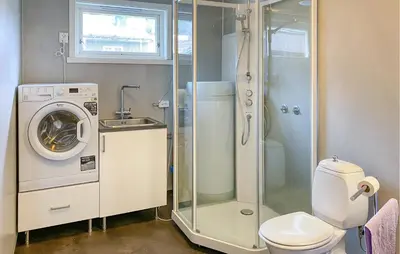 a bathroom with a toilet and a washing machine at Stunning Apartment In Eidsvåg I Romsdal in Toven