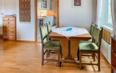a dining room table with green chairs in a kitchen at Stunning Apartment In Eidsvåg I Romsdal in Toven
