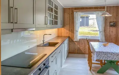a kitchen with white cabinets and a table and a window at Stunning Apartment In Eidsvåg I Romsdal in Toven