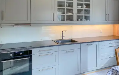 a kitchen with white cabinets and a sink at Stunning Apartment In Eidsvåg I Romsdal in Toven