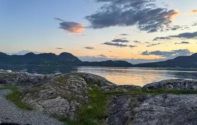 a sunset over a body of water with rocks at Amazing Home In Vikebygd With Wifi in Vikebygd