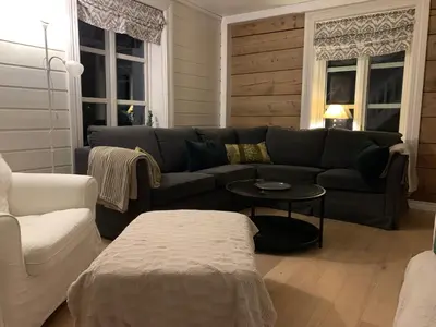 a living room with a couch and a table at Stryn Golden Resort-«Skulehuset» in Stryn