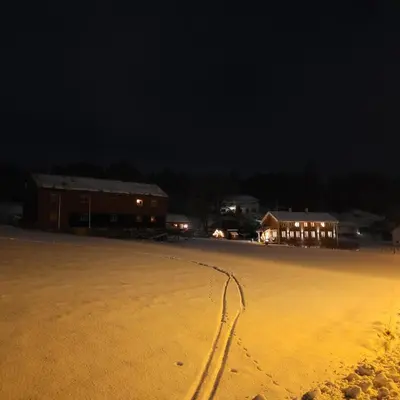 an empty parking lot at night with footprints in the snow at Åkviktunet hytte Sør in Averoy