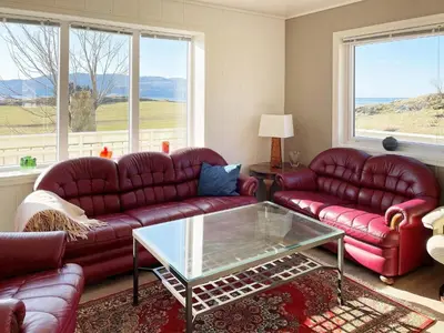 a living room with red couches and a glass table at 8 person holiday home in Bremanger in Grotle