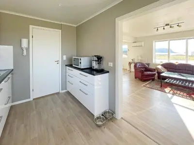 a kitchen with a counter with a microwave and a living room at 8 person holiday home in Bremanger in Grotle