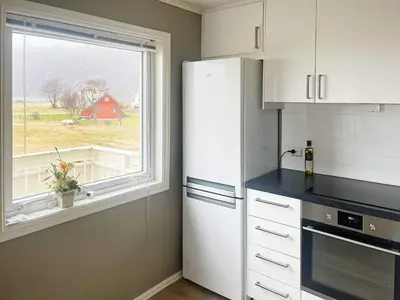 a kitchen with a white refrigerator and a window at 8 person holiday home in Bremanger in Grotle