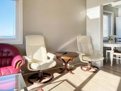 a living room with two chairs and a table at 8 person holiday home in Bremanger in Grotle