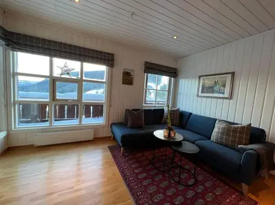 a living room with a blue couch and a table at Leilighet i Uvdal med nydelig utsikt in Sønstebø