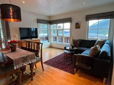 a living room with a couch and a table at Leilighet i Uvdal med nydelig utsikt in Sønstebø
