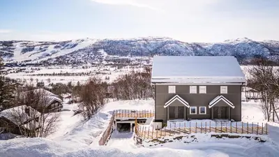 a house with a snow covered roof in the snow at Gullstein in Geilo