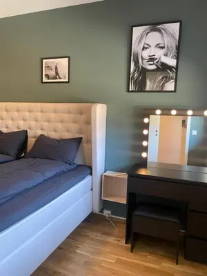 a bedroom with a bed with a mirror and a desk at Strøken leilighet inkl parkeringskjeller. in Trondheim