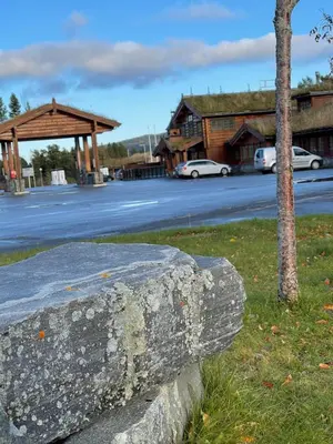 a stone wall next to a street with a building at Oppdalsporten Motell in Oppdal