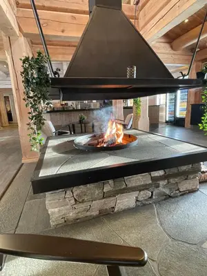 a fire pit in a living room with a chandelier at Oppdalsporten Motell in Oppdal