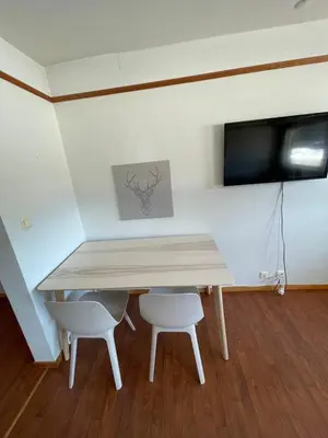 a dining room table with two chairs and a television at Oppdalsporten Motell in Oppdal