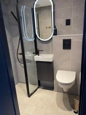 a bathroom with a toilet and a sink and a mirror at Oppdalsporten Motell in Oppdal