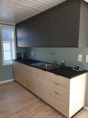 a kitchen with a sink and black counter top at Romslig og særegent hus in Skodje