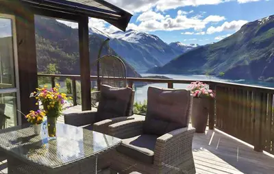 a balcony with a table and chairs and a view of mountains at Lovely Home In Valldal in Valldal