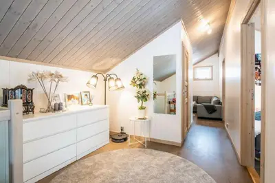 a living room with white walls and a wooden ceiling at A wonderful estate of two houses for all seasons! in Trysil