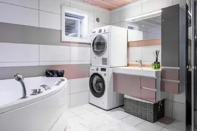 a bathroom with a washing machine and a sink at A wonderful estate of two houses for all seasons! in Trysil