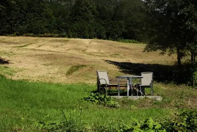 two chairs and a table in the middle of a field at Jølster Lake View in Årdal