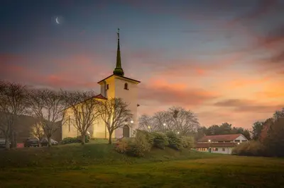 a church with a steeple on top of a field at A beautiful 3-bedroom apartment with stunning views and free parking in Bergen