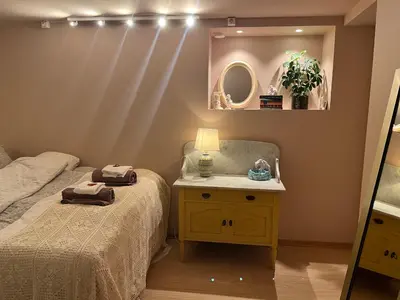 a bedroom with a bed and a table with a mirror at New beautiful flat, parking! in Bergen