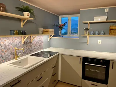 a kitchen with a sink and a stove and a window at New beautiful flat, parking! in Bergen
