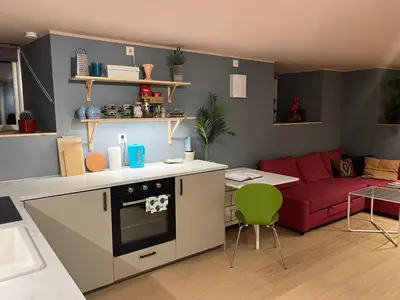 a kitchen and a living room with a red couch at New beautiful flat, parking! in Bergen