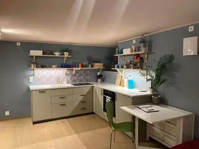 a kitchen with a desk and a table with a chair at New beautiful flat, parking! in Bergen