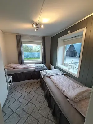 a bedroom with two beds and a window at 3-roms leilighet, innsjekk uten vert. Egen inngang in Ålesund