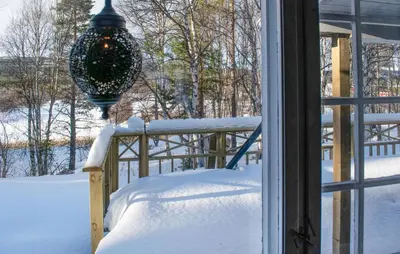 a snow covered porch with a christmas ornament hanging from a window at Gorgeous Home In Os I Østerdalen in Os
