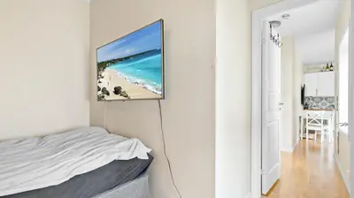 a bedroom with a bed and a painting on the wall at Bergen Sentrum: Koselig leilighet med 2 soverom! in Bergen