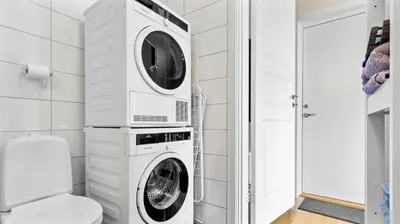 a white laundry room with a washer and dryer at Bergen Sentrum: Koselig leilighet med 2 soverom! in Bergen
