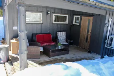 a screened in porch with a red chair and a table at Hus nær lillehammer og sjusjøen in Lillehammer