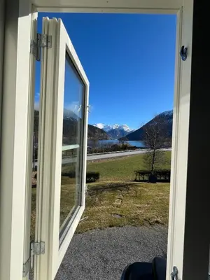 an open door with a view of a field at Skogly - det gode livet på landet in Stryn