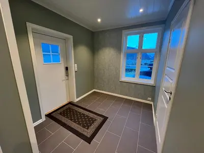 an empty room with a door and a window at Skogly - det gode livet på landet in Stryn