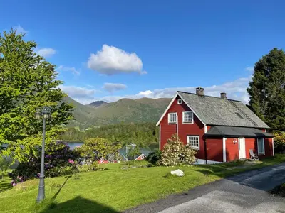 a red house on the side of a road at Krokenes in Sylte