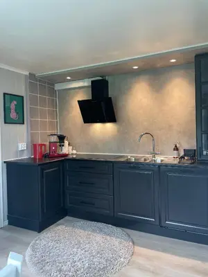 a kitchen with blue cabinets and a sink at Krokenes in Sylte