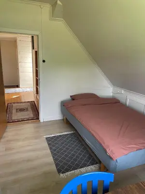 a small bedroom with a bed and a staircase at Krokenes in Sylte