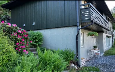 a small house with a balcony and some flowers at Fjordview 35 in Lofthus