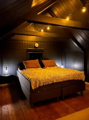 a bed in a room with a wooden ceiling at Stabbur med fantastisk utsikt! in Steinkjer