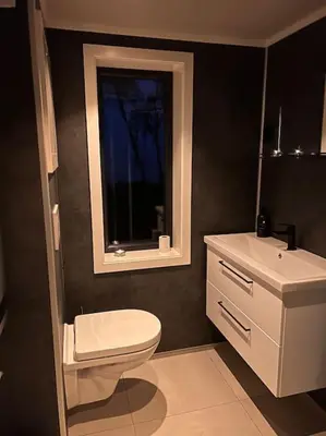 a bathroom with a toilet and a sink and a window at Stabbur med fantastisk utsikt! in Steinkjer