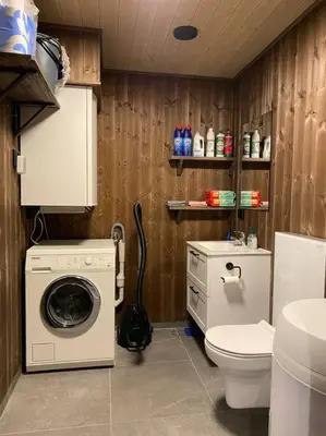 a bathroom with a washing machine and a toilet at Ladebua in Brunstad